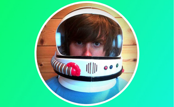 A portrait of Brad Frost wearing a retro space helmet.